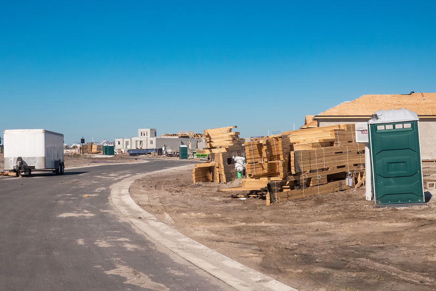 Part of a residential development in Florida, with stacks of roof trusses and lumber by a home under construction along a new street. File photo: Ken Schulze, Shutter Stock, licensed.